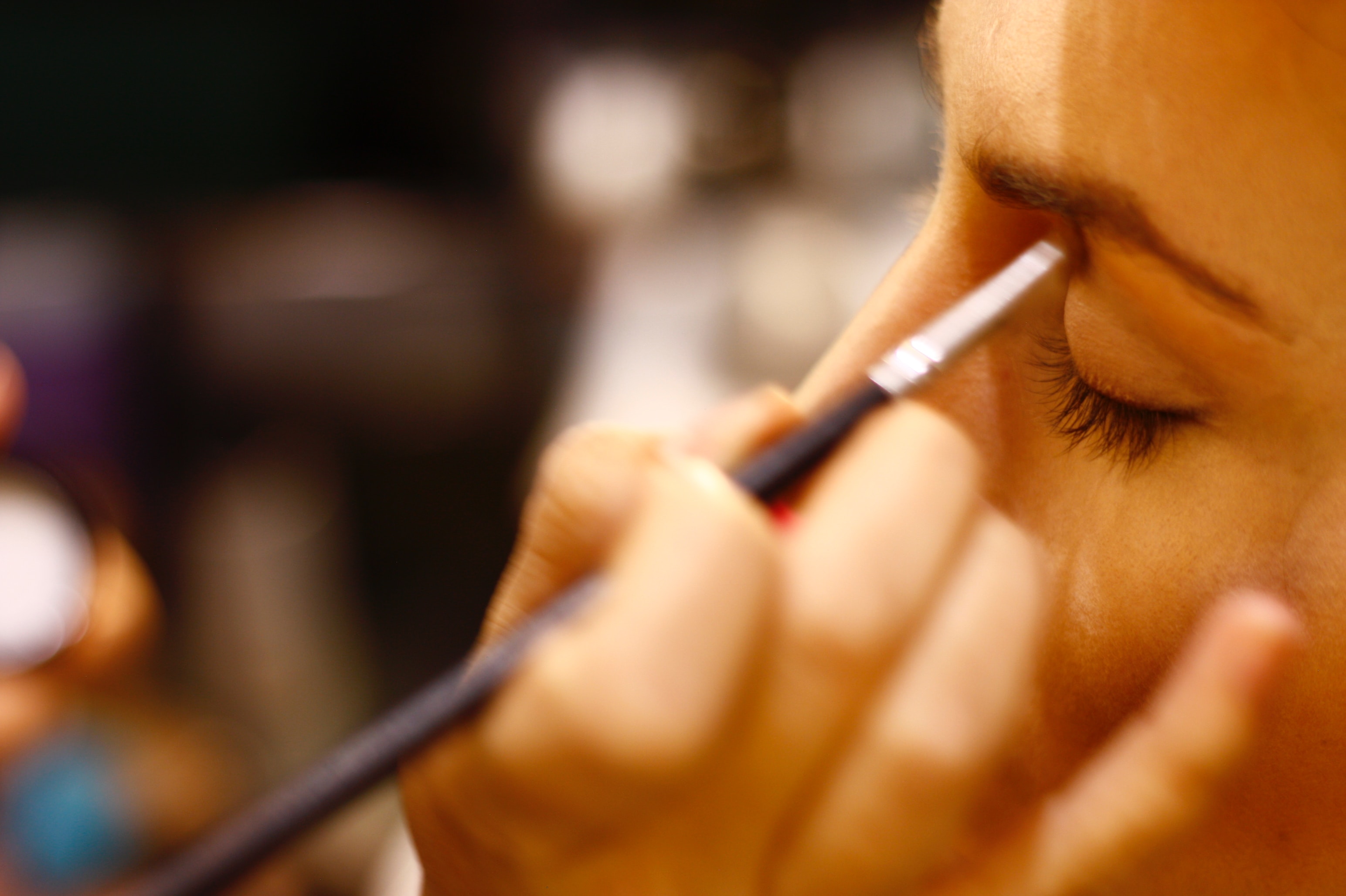 woman applying eye shadow to another woman's face